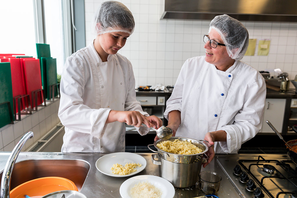 Docent geeft praktijkles aan leerling